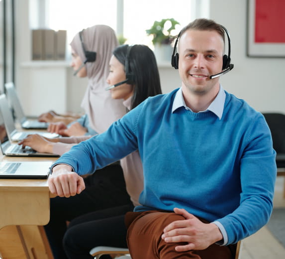 Office worker at desk taking a call via headset